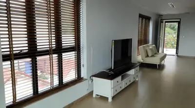a living room with a flat screen tv and a chair at Thebirdhouse Patong Phuket 301 in Patong Beach