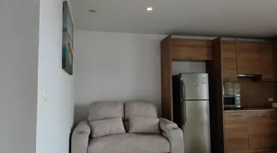 a living room with a chair and a refrigerator at Thebirdhouse Patong Phuket 301 in Patong Beach