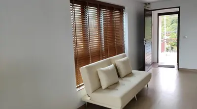 a white couch sitting in a room with a window at Thebirdhouse Patong Phuket 301 in Patong Beach