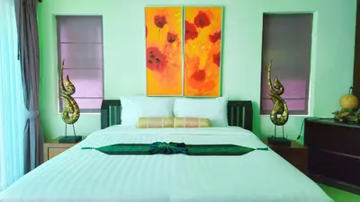 a bedroom with a large white bed with a bow on it at Prima Karon Villa in Karon Beach