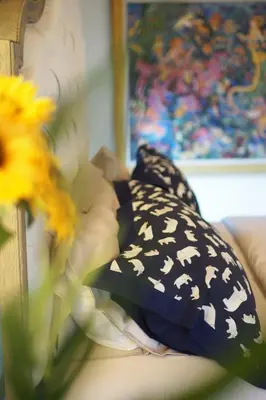 a couch with black and white pillows and flowers at Villa Omloft in Changwat Phuket