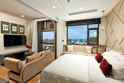 a bedroom with a bed and a couch and a tv at Seaview 1bdr apartment Karon PRO-613 in Karon Beach