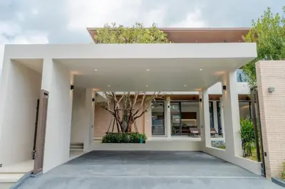 a white building with a tree in the middle at Liva Villa near Rawai Phuket in Ban Saiyuan (1)