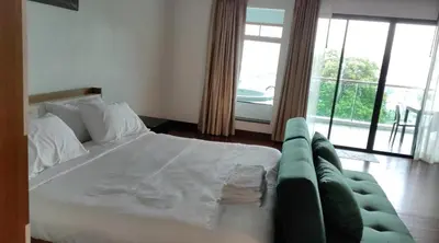 a bedroom with a large bed and a couch at Thebirdhouse Patong Phuket 302 in Patong Beach