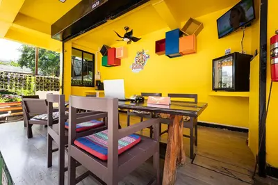 a dining room with a wooden table and chairs at myPatong Social Hostel in Patong Beach