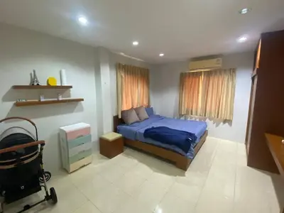 a bedroom with a blue bed and a window at Home House in Ban Bang Chak