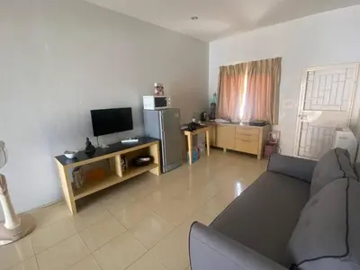 a living room with a couch and a television at Home House in Ban Bang Chak