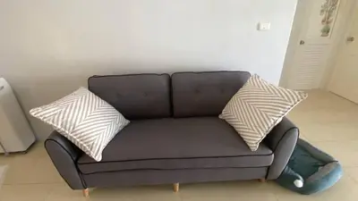 a black couch with two pillows on top of it at Home House in Ban Bang Chak