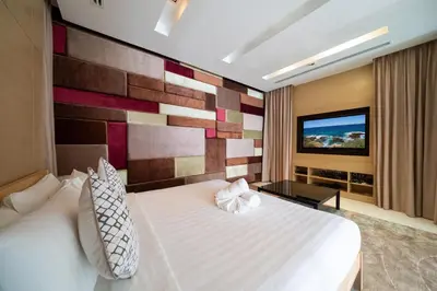a hotel room with a bed and a tv at Exclusive Oceanfront Living, 5BR Pool Villa Elegance in Ko Lek