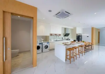 a large kitchen with a counter and bar stools at Ola-Villa in Kamala Beach