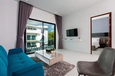 a living room with a blue couch and a table at Private Pool View 1BR Apartment in Naiharn Residence near Beach, UTN D502 in Rawai Beach