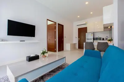a living room with a blue couch and a tv at Private Pool View 1BR Apartment in Naiharn Residence near Beach, UTN D502 in Rawai Beach
