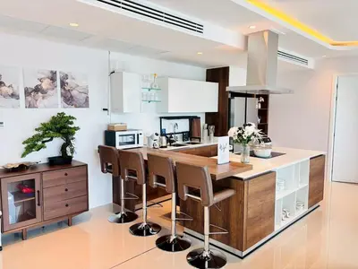 a kitchen with a large wooden island with bar stools at 2BR 4Beds Luxury Condo Pool & Fitness in Phuket Town