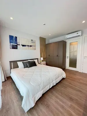 a bedroom with a large white bed and wooden floors at 2BR 4Beds Luxury Condo Pool & Fitness in Phuket Town
