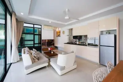 a living room with two white chairs and a kitchen at V68 Paradise Found 2BR Villa Bliss in rawai in Kata Beach