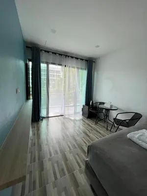 a bedroom with a bed and a table and chairs at Los Patios Hostel Phuket in Mai Khao Beach