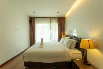 a bedroom with a bed with a cat sitting on it at V69 15min Convenient to Patong Building Gym in Kamala Beach