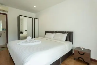 a bedroom with a large white bed with a mirror at V69 15min Convenient to Patong Building Gym in Kamala Beach