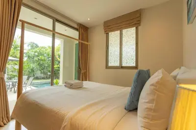 a bedroom with a large bed and a large window at V91 Where The Rich People Go Trichada Resort in Thalang