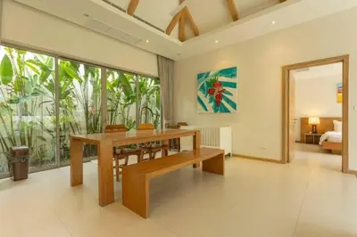 a dining room with a table and a large window at V91 Where The Rich People Go Trichada Resort in Thalang