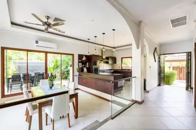 a large kitchen with a dining table and a ceiling fan at Surin villa by Pattara in Surin Beach