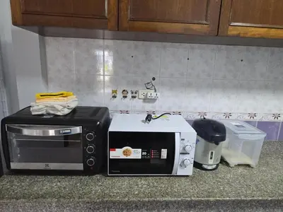 a microwave and a toaster on a kitchen counter at Diamond Home in Phuket in Ban Rangeng