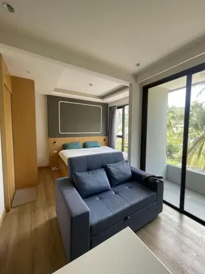a bedroom with a couch and a bed with a screen at Studio surin-bangtao beach in Surin Beach