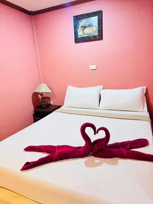 a bed with two red towels in the shape of a heart at Phi Phi Treetop in Phi Phi Don