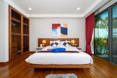 a bedroom with a large bed and a large window at Vanille Villa in Balinese style with swimming pool in Ban Saiyuan (1)