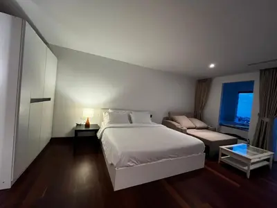 a bedroom with a white bed and a couch at Thebirdhouse Patong Phuket 202 in Patong Beach