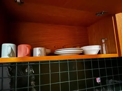 a wooden shelf with plates and dishes on it at Thebirdhouse Patong Phuket 202 in Patong Beach