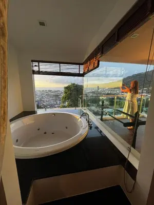 a bathroom with a large window and a large tub at Thebirdhouse Patong Phuket 202 in Patong Beach