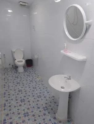 a bathroom with a sink and a toilet and a mirror at Reggaein in Phi Phi Don