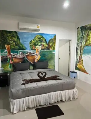 a bedroom with a large painting on the wall at Reggaein in Phi Phi Don