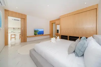 a bedroom with a large white bed with a wooden headboard at Modern Elegance & Tropical Vibe - 4BR Pool Villa in New Build Residence Lux Pride 2 V10 in Bang Tao Beach