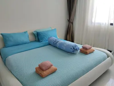 a bed with two towels and two pillows on it at Luxury spacious 3 bdr apartment Pandora residence in Nai Harn Beach