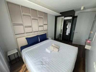 a bedroom with a large white bed with blue pillows at Condo Surin-Bangtao Beach in Surin Beach