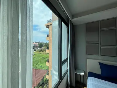 a bedroom with a window with a bed and a view at Condo Surin-Bangtao Beach in Surin Beach