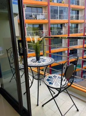 a table and chairs with a plant on a balcony at Skyline Retreat in Ban Mai Salae