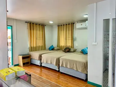 a bedroom with two beds and a mirror at Patcharin Home Stay in Ko Yao Yai