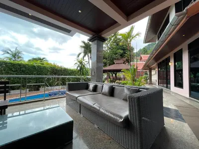 a living room with a couch and a glass table at Вилла в сердце Пхукета in Surin Beach