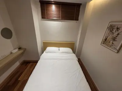 a small bed in a small room with a window at Beachside Gem with Lake, Cafes and more in Rawai Beach