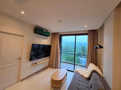 a living room with a couch and a large window at Beachside Gem with Lake, Cafes and more in Rawai Beach