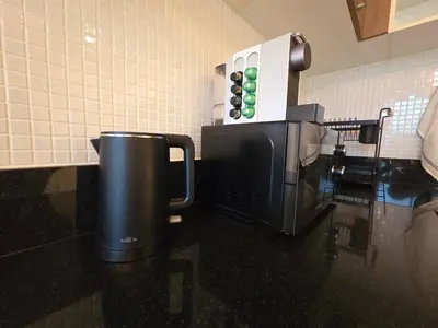 a kitchen with a coffee maker and a microwave at Beachside Gem with Lake, Cafes and more in Rawai Beach