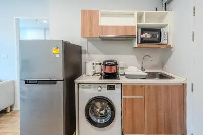 a small kitchen with a washing machine and a refrigerator at ZcapeX2 94-18 by Silqstay in Thalang