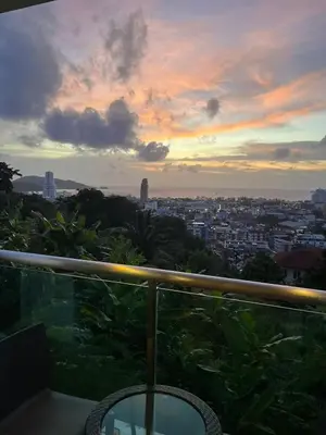 a view of a city at sunset from a balcony at Thebirdhouse Patong Phuket103 in Patong Beach