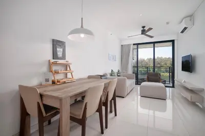 a dining room with a wooden table and chairs at Cassia Residences in Laguna by Banyan Living in Laguna Phuket