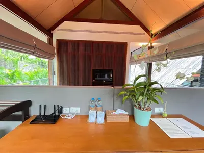 a table with bottles of water and a plant on it at Laemsingh Villa 1 - Luxury Villa 5 Bedrooms in Surin Beach