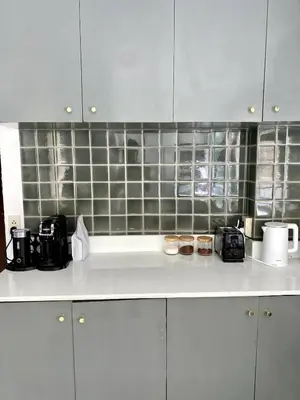 a kitchen with white cabinets and black tiles at Jungle Pool Villa in Chalong in Changwat Phuket