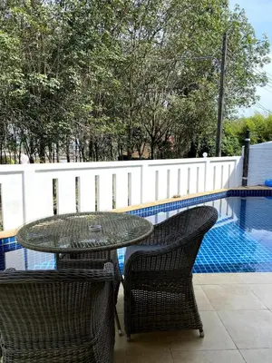 a table and two chairs next to a swimming pool at Jungle Pool Villa in Chalong in Changwat Phuket